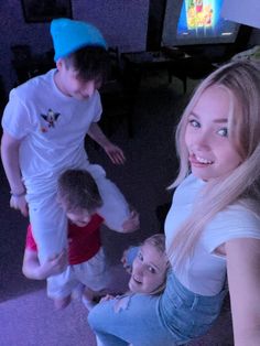 three young people standing in front of a television