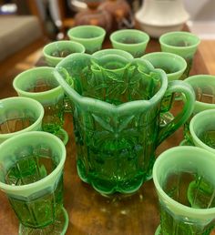 green glass cups are arranged on a table