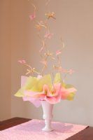 a white vase filled with flowers on top of a wooden table