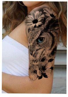 a woman's arm with an owl and flowers on it