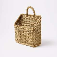 a woven basket on a white background with the handle extended to it's side