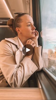 a woman sitting on a train looking out the window