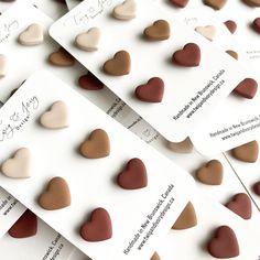 many hearts are arranged on white cards with brown and tan colors in the shape of small hearts