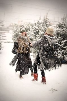 two women walking in the snow holding hands