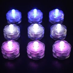 several lit candles are arranged in rows on a black surface