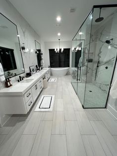 a large bathroom with two sinks and a walk in shower next to a bathtub