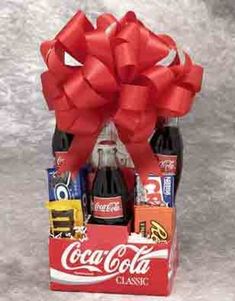 a coca - cola bottle wrapped in red ribbon and filled with assorted candy bars