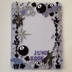 a photo frame decorated with black and white paper, silver stars, and other decorations