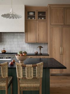 two wicker chairs sit in front of a kitchen island