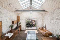 a living room filled with furniture and a skylight over the top of it's roof