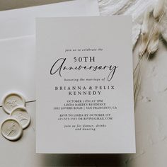 the wedding stationery is laid out on top of an envelope and two wax stampers