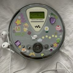 an electronic device with many stickers on it's face and earbuds