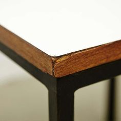 the edge of a wooden table with white paper on it's top and bottom