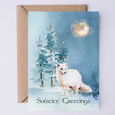 a greeting card with an image of a white wolf standing in front of a snowy pine tree