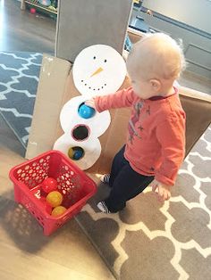 a toddler playing with a toy snowman