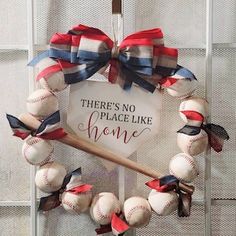 a wreath with baseballs and a bat hanging on the front of a door that says, there's no place like home