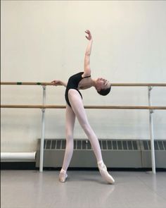 a young ballerina is practicing her ballet moves