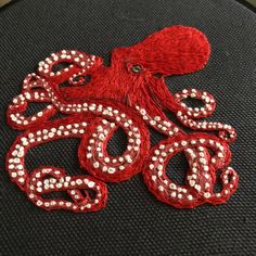 an octopus with red and white beads on it