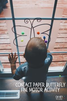 a toddler looking out the window at something outside with text overlay that reads contact paper butterfly fine motor play