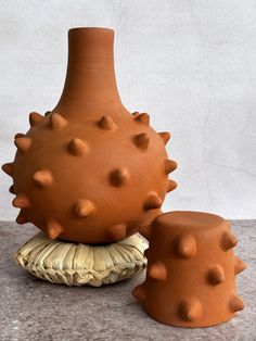 two clay vases sitting next to each other on a table