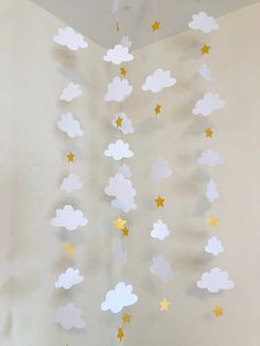 a crib mobile with clouds and stars hanging from it's sides in a nursery room