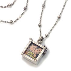 "A miniature photo box holds a retro comic image between two glass panes. You can easily remove them and replace with your own photos or images. Burnished silver finish. 29\" metal beaded chain. Locket is 0.75\" L x 0.75\" W. Arrives ready to gift. Made in our Los Angeles studio. Contact us for bulk pricing and wholesale information." Chain Locket, Tech Jewelry, Glass Panes, Box Necklace, Locket Bracelet, Locket Pendant Necklace, Photo Box, Retro Comic, Friend Necklaces