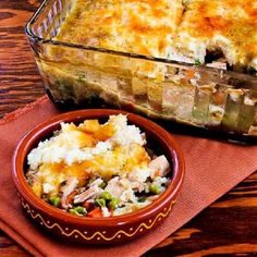 a casserole dish with mashed potatoes and vegetables on a red placemat