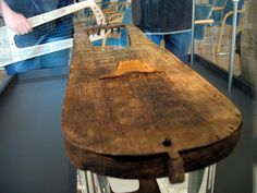 an old wooden boat is on display in a glass case