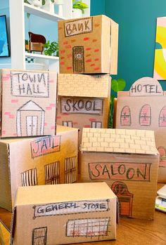 cardboard boxes are stacked on top of each other in front of a blue wall with the words town hall and saloon painted on them