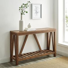 a wooden console table in front of a window with a potted plant on top