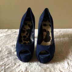 a pair of blue high heeled shoes sitting on top of a bed