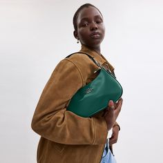 Our Teri Shoulder Bag has a '90s-inspired silhouette with many shades to match your personal style. Crafted of novelty and Spazzolato leather this designer shoulder bag with leather strap doubles as a crossbody thanks to its detachable strap. It features a multifunction pocket and two credit card slots to comfortably fit your keys wallet and phone without feeling weighed down. And with its zip-top closure this leather shoulder bag keeps your favorite day (and night) items secure. Trendy Leather Pouch Baguette Bag, Luxury Everyday Baguette Bag With Phone Holder, Chic Leather Baguette Bag For Mobile Phone, Leather Baguette Evening Bag With Phone Pocket, Trendy Green Leather Phone Bag, Trendy Everyday Baguette Bag With Cell Phone Pocket, Leather Baguette Bag Mobile Phone Everyday, Leather Baguette Mobile Phone Bag For Everyday, Trendy Leather Phone Bag For Evening