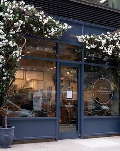 the front window of a bakery with white flowers on it