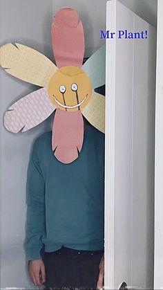 a man standing in front of a door wearing a paper bee mask