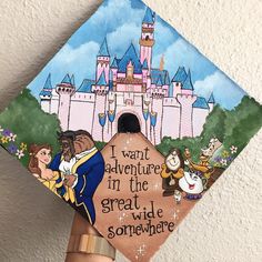 a hand holding up a decorated graduation cap that says i want adventure in the great wide somewhere