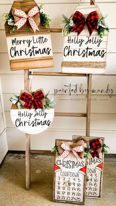 three wooden christmas signs with bows on them