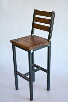 a wooden chair sitting on top of a metal frame countertop next to a white wall