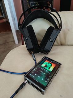 a cell phone and headphones sitting on top of a couch