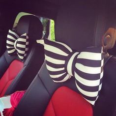 two black and white striped bow ties in the back seat of a car with red seats