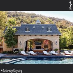 an outdoor pool with lounge chairs and a fireplace