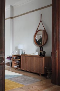 a room with a large mirror and wooden furniture