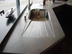 a kitchen sink sitting on top of a counter next to a window