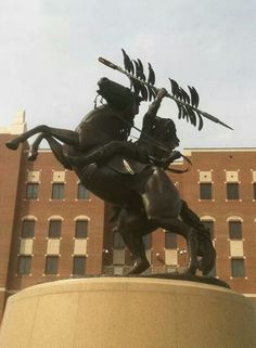 a statue of a man riding on the back of a horse with an arrow in its mouth