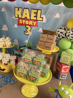 a table topped with lots of desserts next to balloons and boxes filled with treats