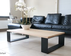 a living room with black leather couches and a coffee table in front of it