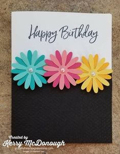 a birthday card with three colorful flowers on it