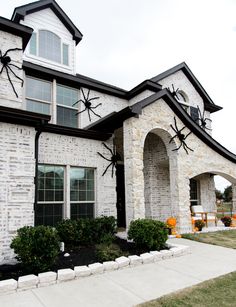 a house decorated for halloween with spider webs and pumpkins