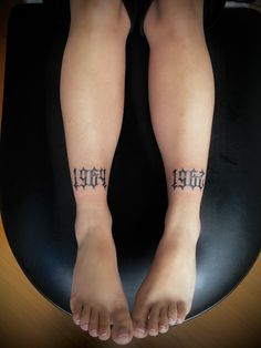 a person sitting on top of a chair with tattoos on their legs and feet in the shape of letters