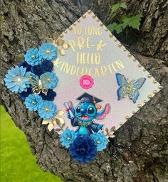 a graduation cap with blue flowers and a stitched stitch on it that says, no long pre - k hello education