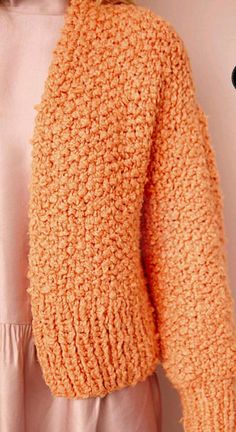 a woman wearing an orange knitted sweater